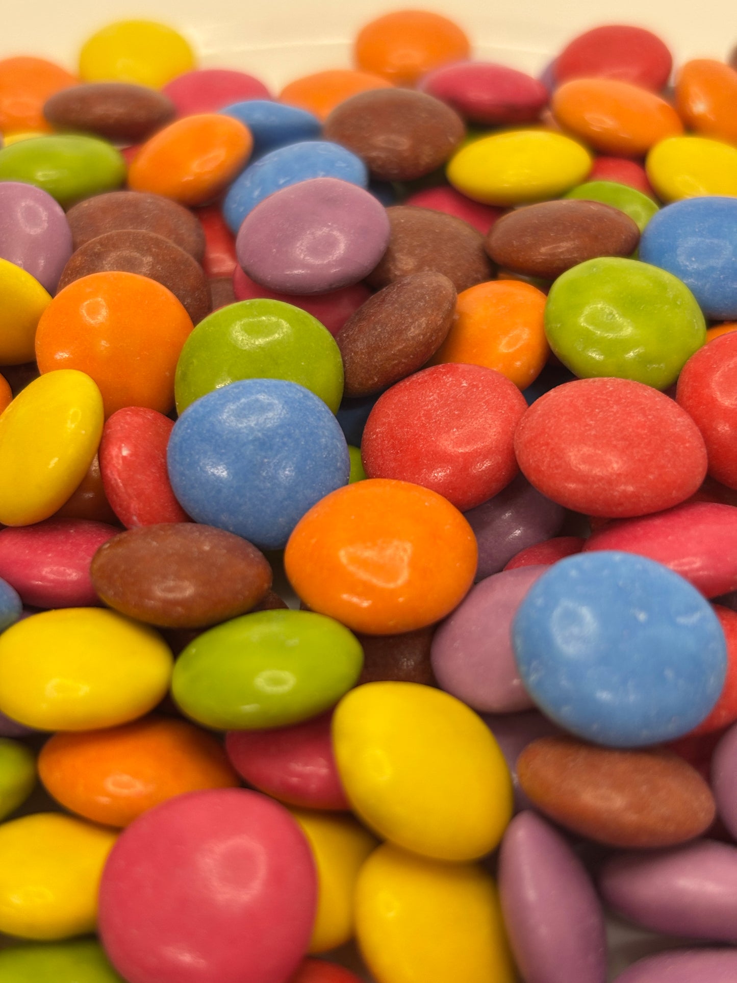 Close-up of colorful chocolate buttons in various bright colors by Select Sweets