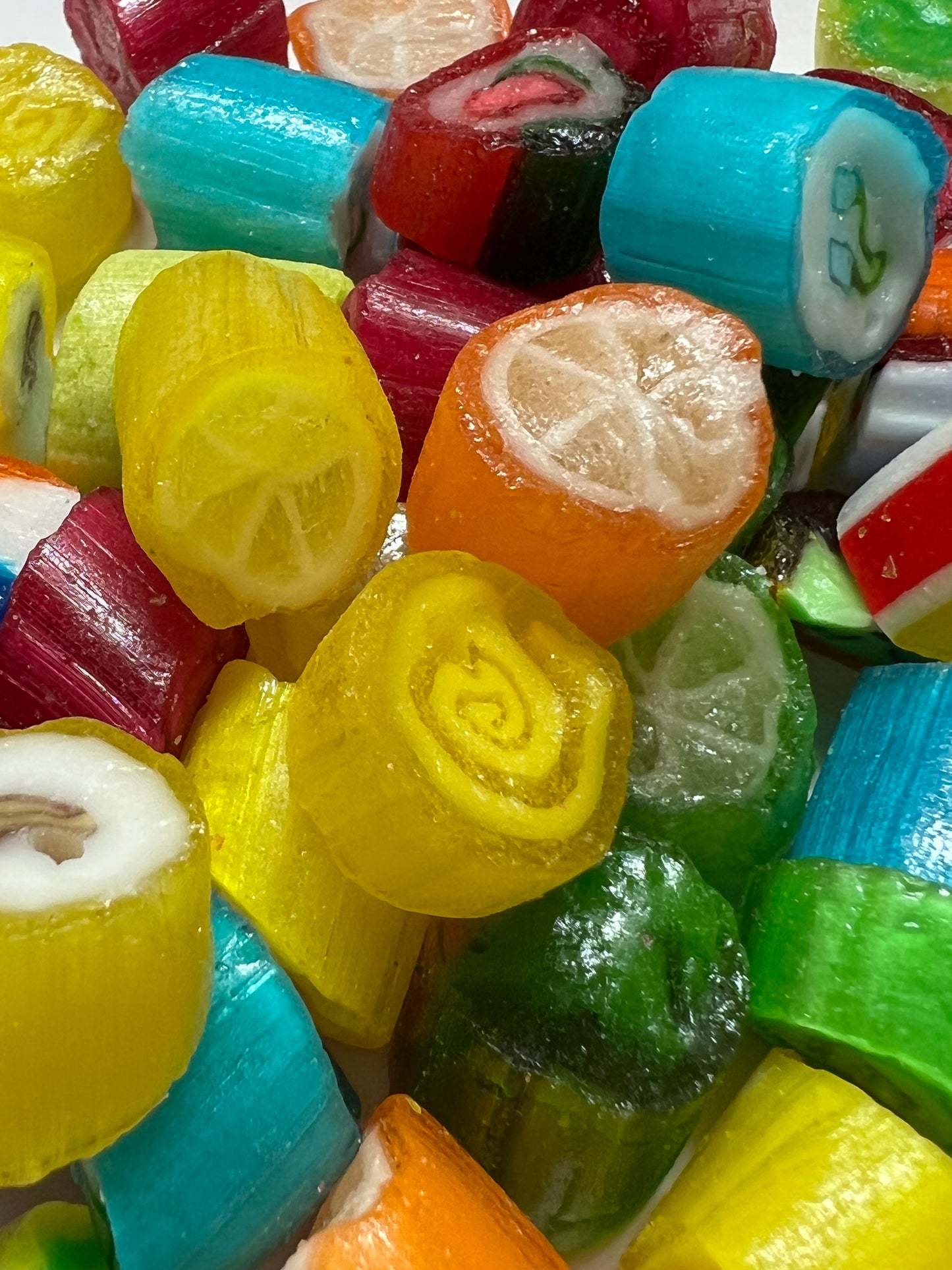 Assorted colorful fruit rock candy pieces featuring various fruit designs and bright colors