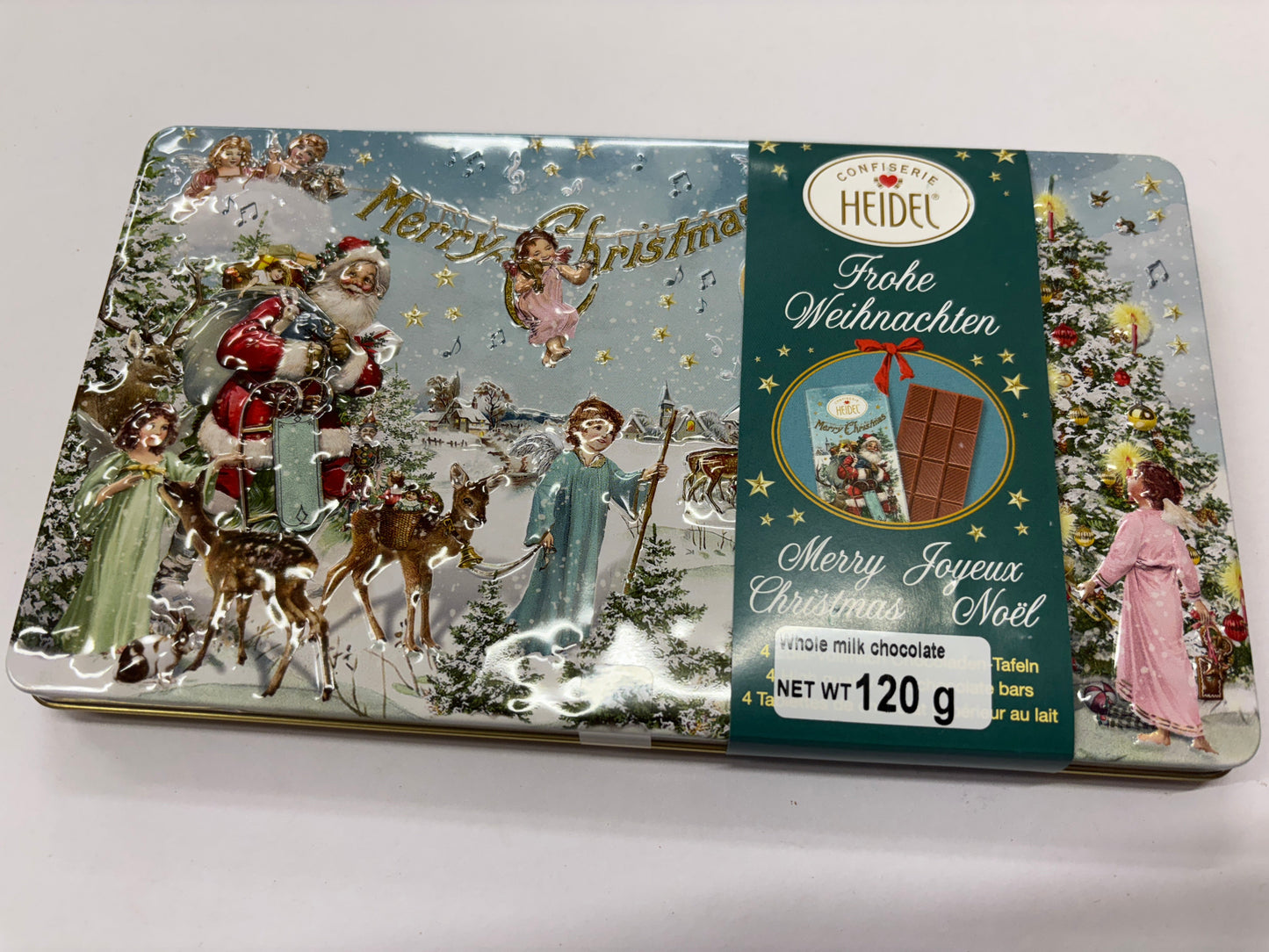Heidel milk chocolate Christmas tin featuring festive holiday illustrations and a charming winter scene