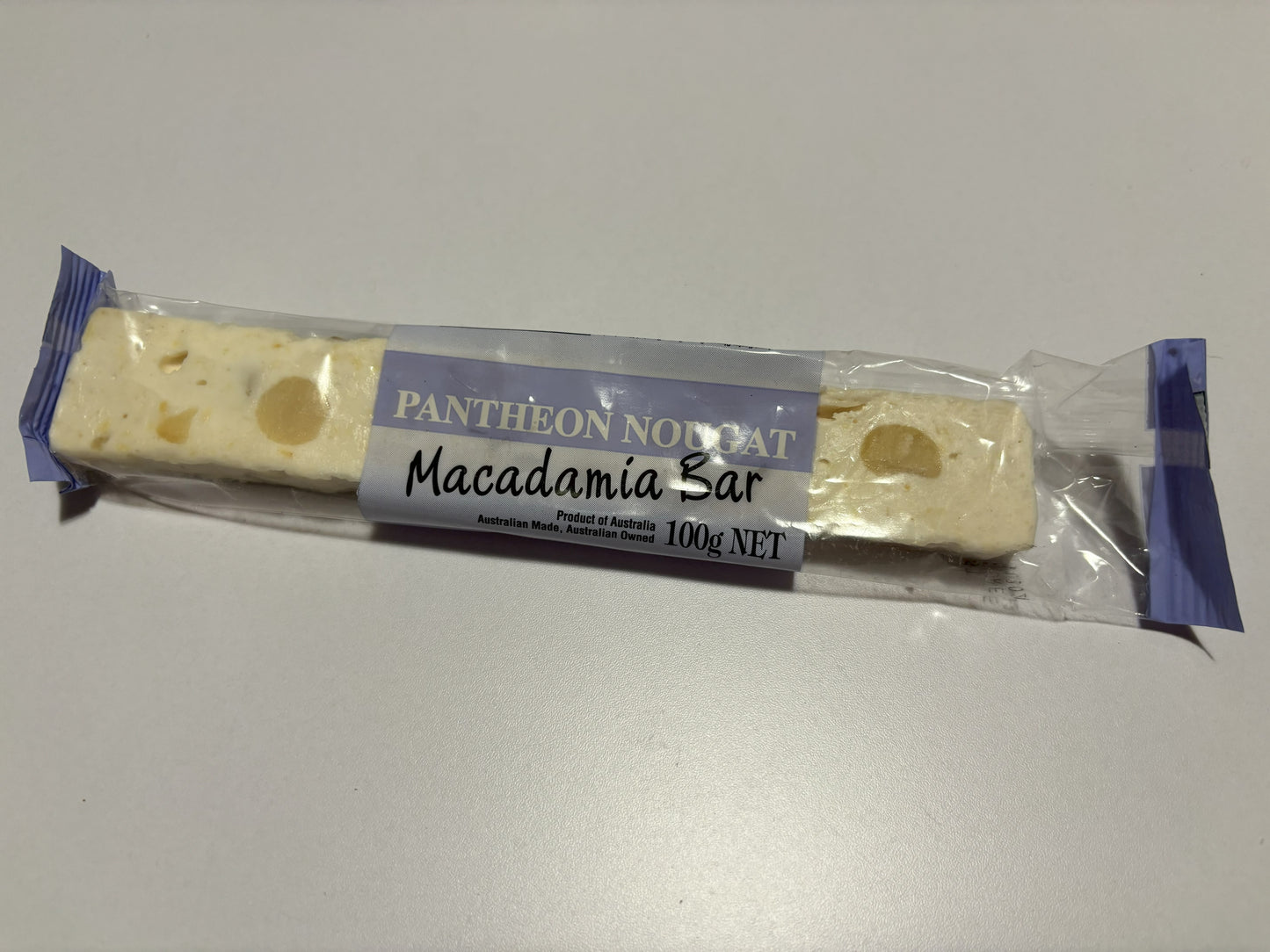 Select Sweets macadamia nougat bar in clear packaging showing white nougat with macadamia nuts