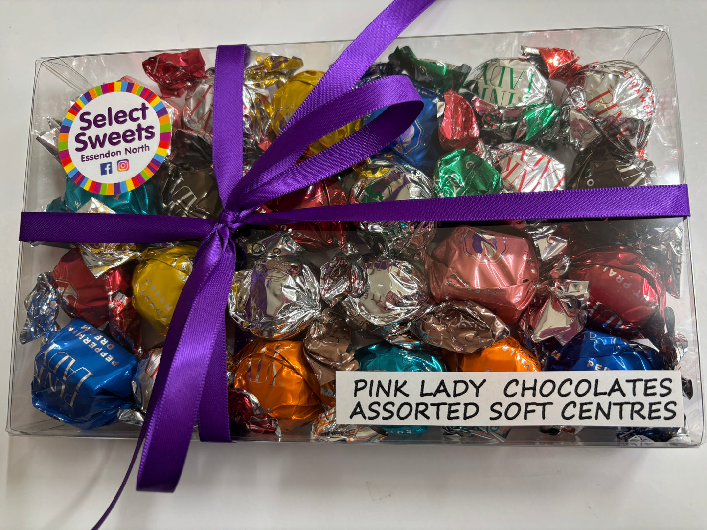 Select Sweets clear gift box of Pink Lady chocolates assorted foil wrapped soft center sweets with purple ribbon