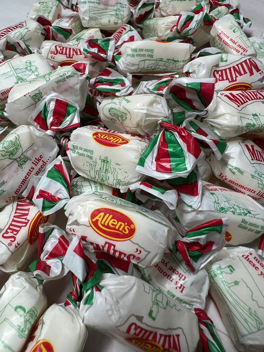 Close-up of Allens Minties bulk candy wrapped in white paper with red green and yellow accents