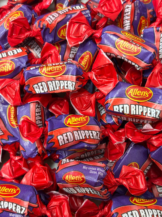 Pile of Allen's red rippers candy wrappers, featuring vibrant red and blue design.