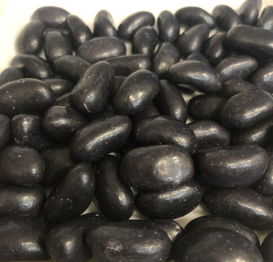 Close-up of SelectSweets black jelly beans piled together with a shiny smooth coating