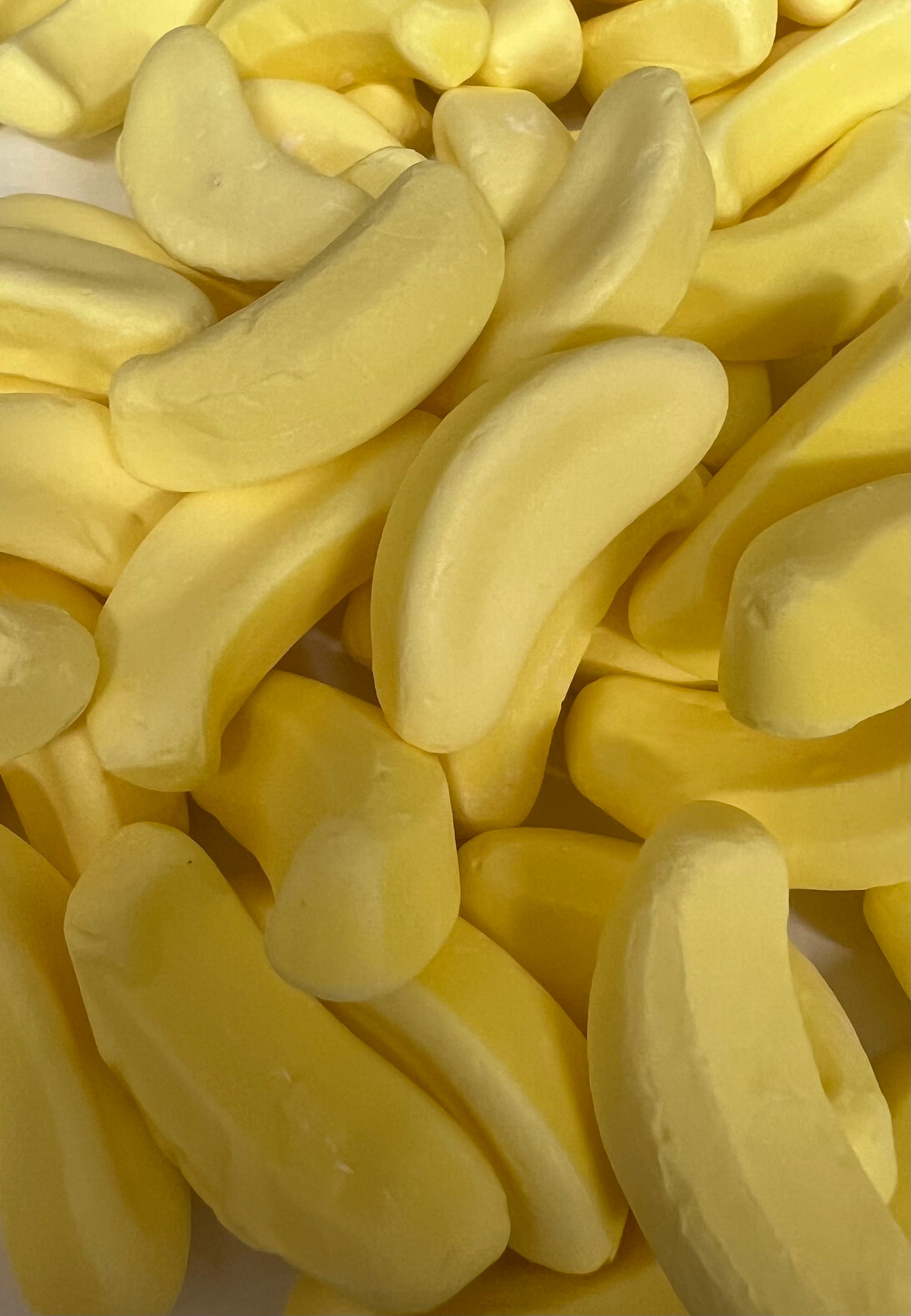 Colorful banana candy from Select Sweets in a pile, shaped like bananas for a fun treat