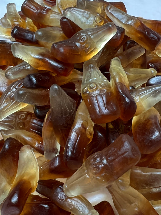 Close-up of SelectSweets gummy cola bottles candy with translucent brown and beige bottle shapes
