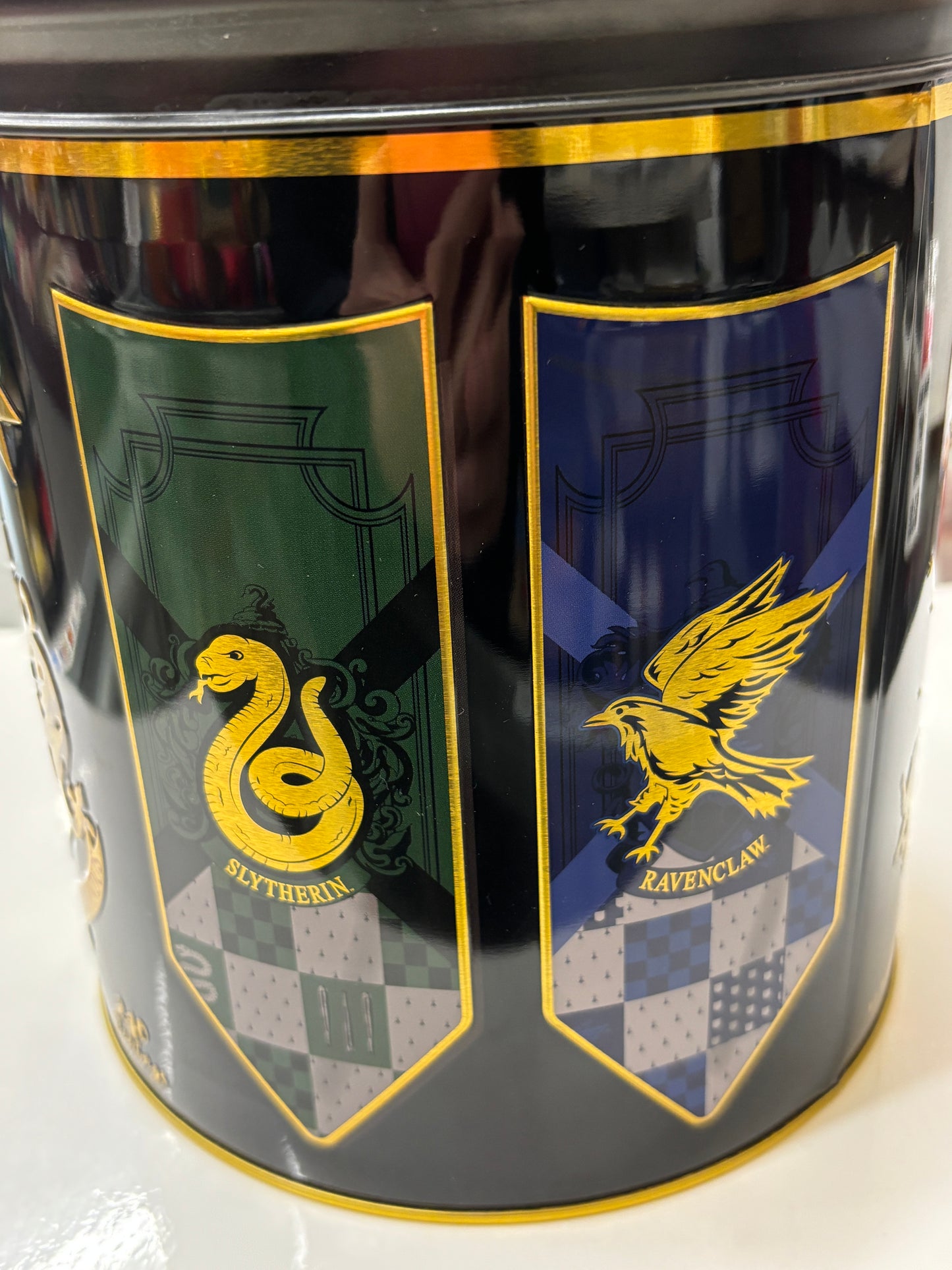 Hogwarts English tea tin featuring Slytherin and Ravenclaw house designs in vibrant colors