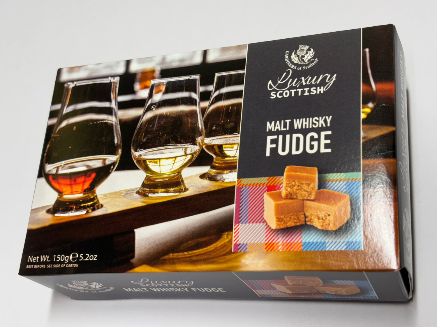 Luxury Scottish whisky fudge box featuring malt whisky fudge cubes with tasting glasses in the background