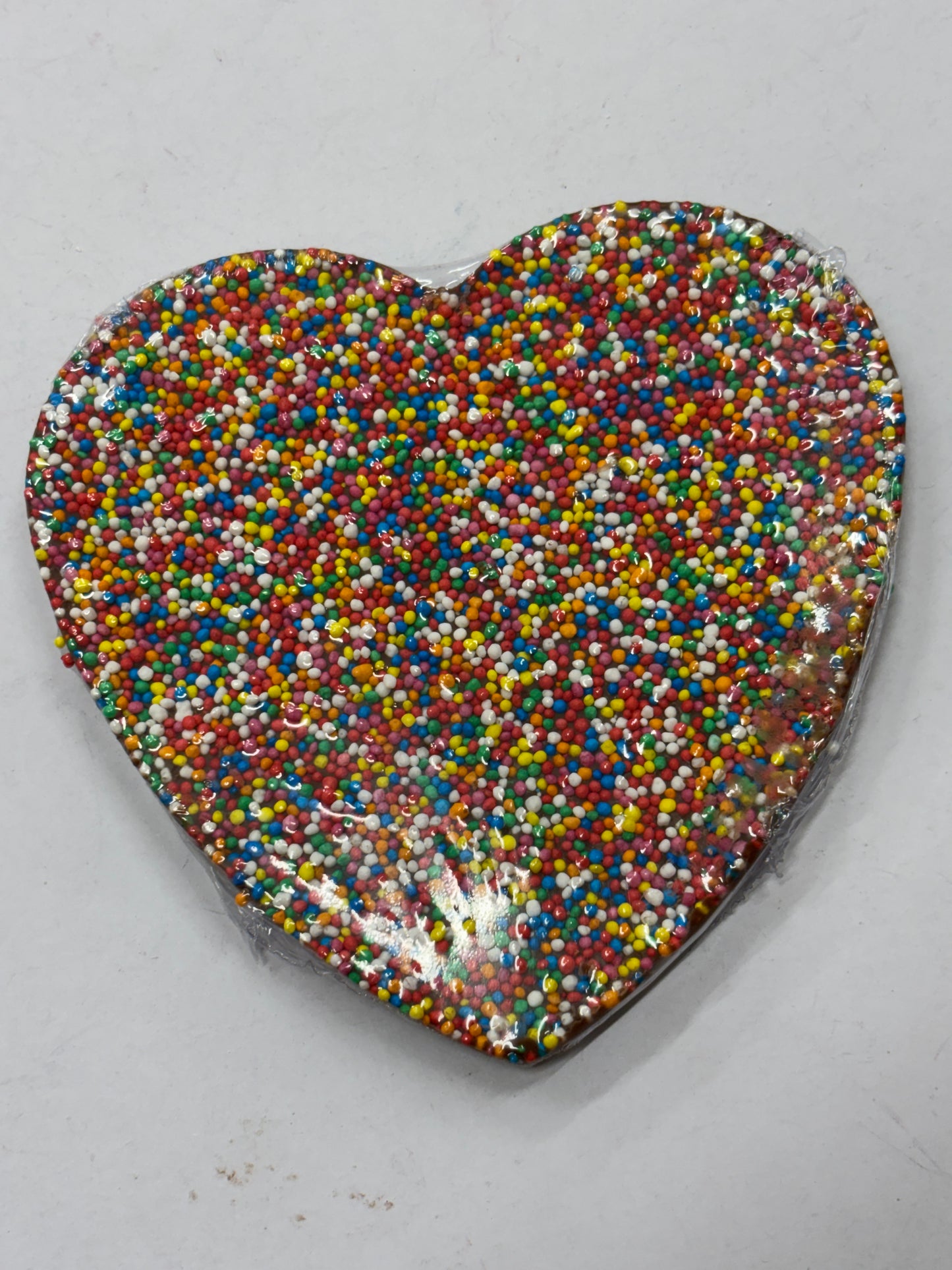 Select Sweets milk chocolate freckle heart covered in colorful sprinkles for a sweet treat