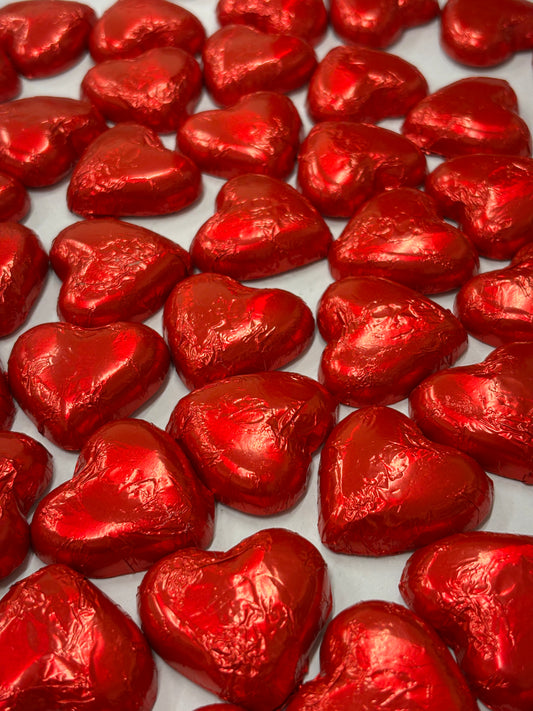 Red foil-wrapped milk chocolate heart candies arranged in an enticing display