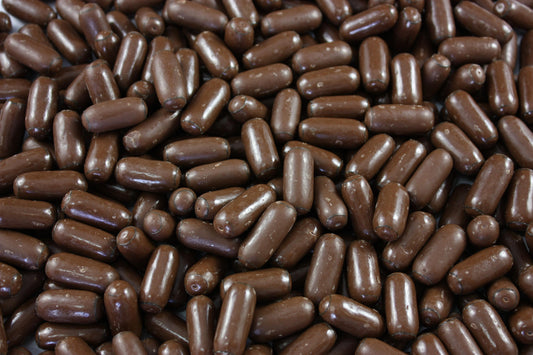 Close-up of SelectSweets milk chocolate licorice bullets with smooth glossy coating