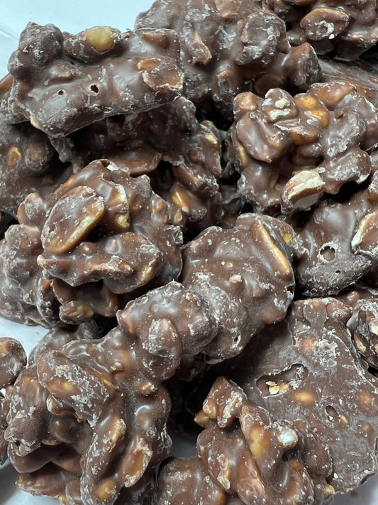 Close-up of SelectSweets milk chocolate peanut clusters with crunchy peanuts coated in smooth milk chocolate