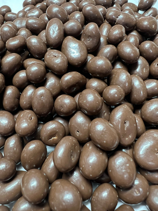 Close-up of SelectSweets milk chocolate sultanas with smooth shiny coating and rich chocolate flavor
