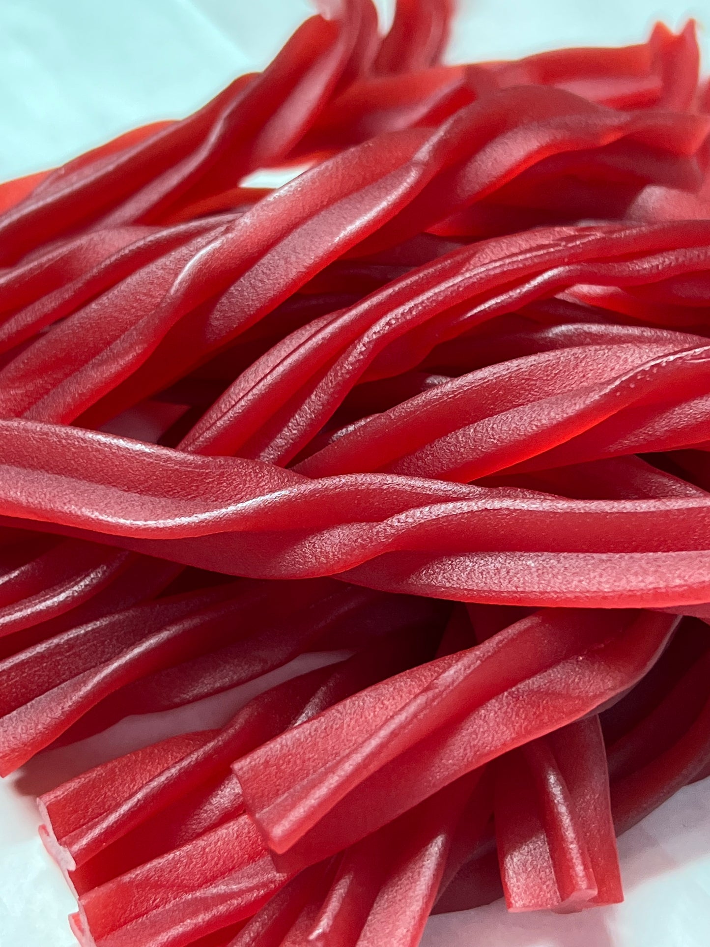 Close-up of bright red SelectSweets raspberry twists candy with a textured surface