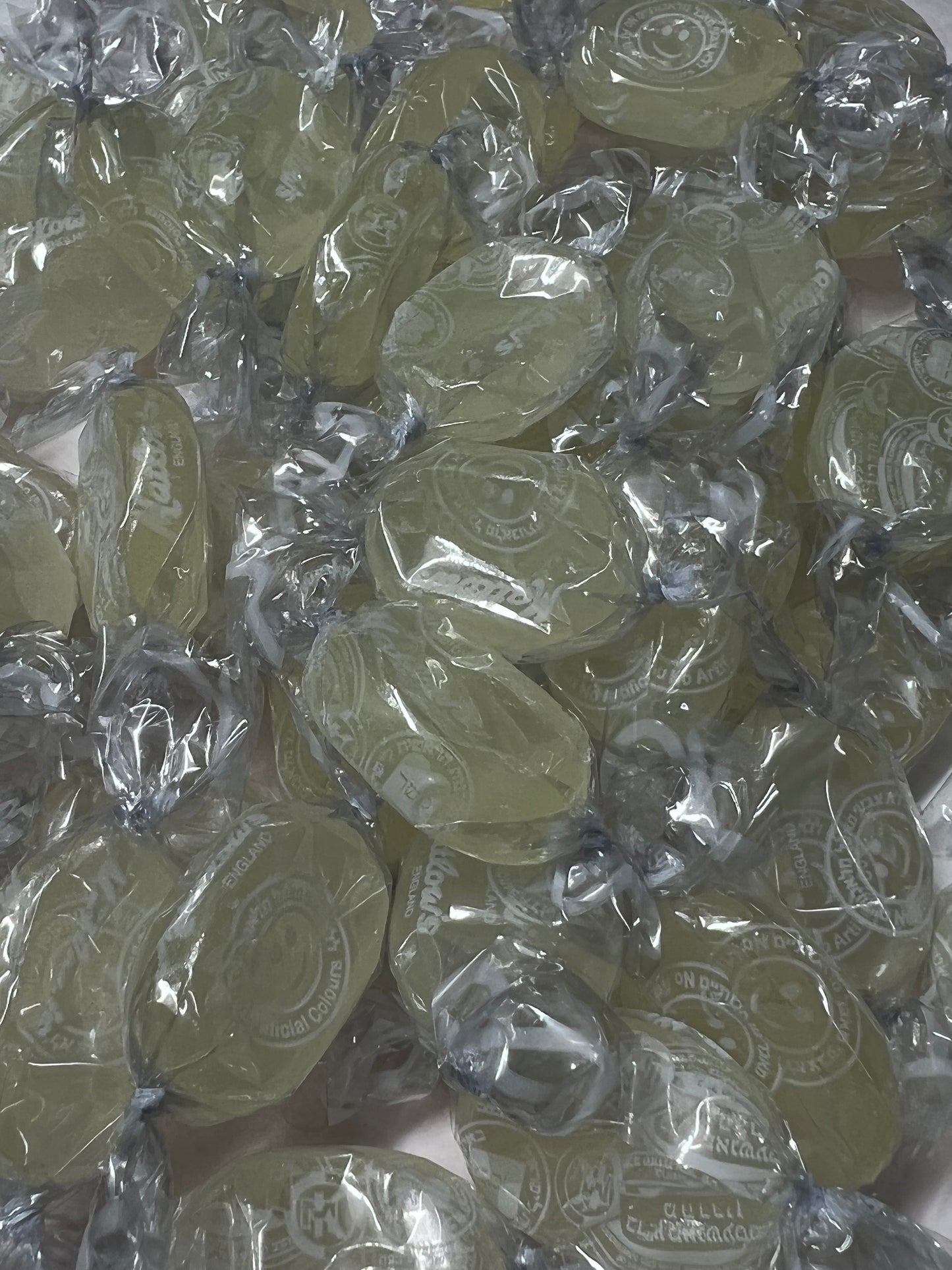 SelectSweets1 sour lemon candy individually wrapped in clear plastic with a yellow tint