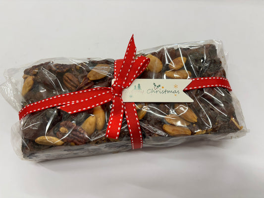 Delicious traditional Christmas fruit cake decorated with nuts and festive ribbon for holiday celebrations